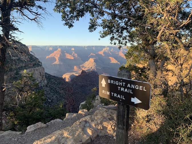 Sign for start of Bright Angel Trail on Grand Canyon's south rim, with a view of the canyon in the background