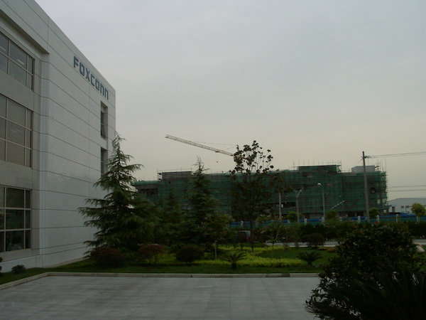 A portion of the front of a Foxconn factory building in Songjiang, China, with another building under construction in the background