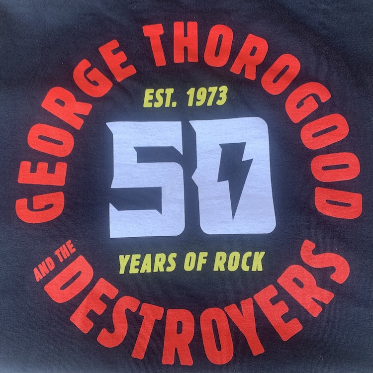 A graphic on a black T-shirt, with the band's name in red in a circle surrounding a large five and zero in white with a lightning bolt in the center of the zero, and additional smaller lettering in yellow above and below the numbers