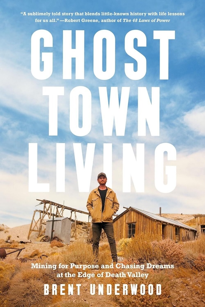 A book cover, listing the title, subtitle, and author's name, with a picture of a man in jeans, a jacket, and a baseball cap, with his hands in his jacket pockets, standing amongst some dried out brush and dirt in front of a few dilapidated wooden structures beneath a partly cloudy sky