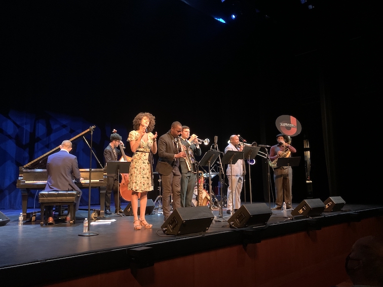 NOJO7 with singer Cyrille Aimée performing on a darkened stage