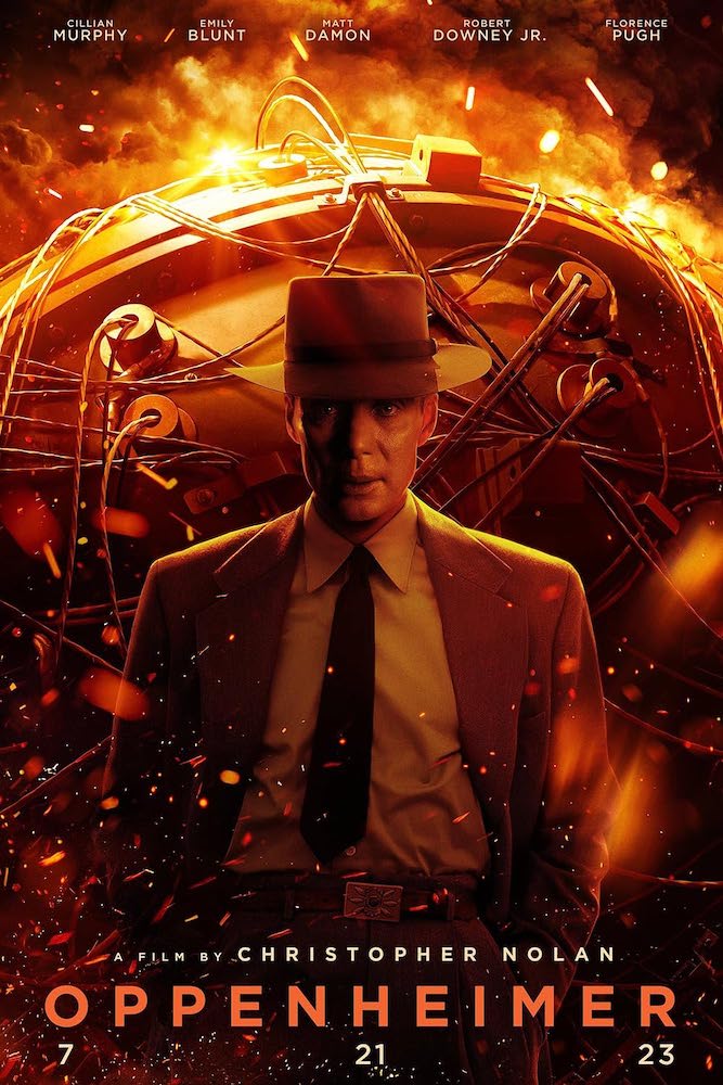 A movie poster containing the title and the stars’ and director’s names, with a monochrome black-and-orange picture of a man in a suit jacket, tie, and hat, shot from the waist up, standing in front of a large metallic, curved container with wires on the exterior, with bits of debris floating in the foreground