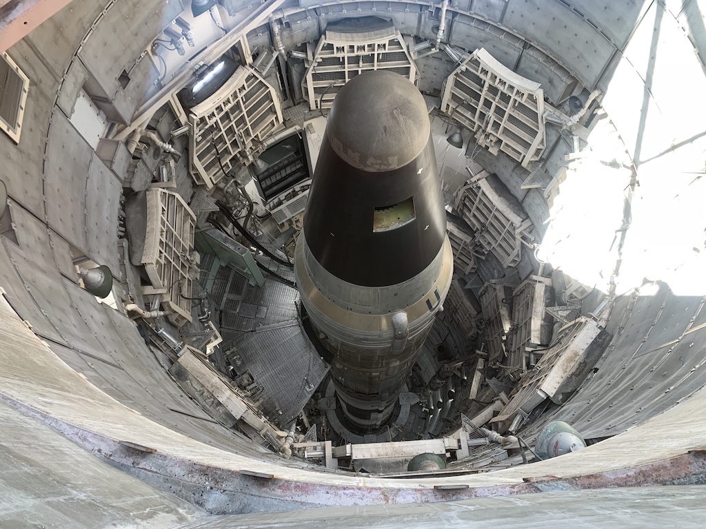 A large missile rocket positioned within a silo, viewed from above